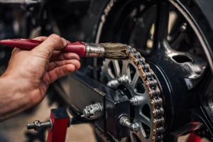 Close-up of a bike chain being cleaned with a brush, showcasing routine maintenance to ensure smooth performance and safety during rides.